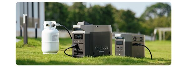 An EcoFlow portable generator connected to an LPG propane bottle outdoors on a lawn, with a smaller EcoFlow power station beside it