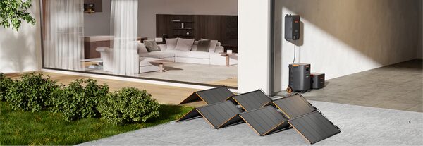 Jackery portable power station with solar panels set up outside a modern home