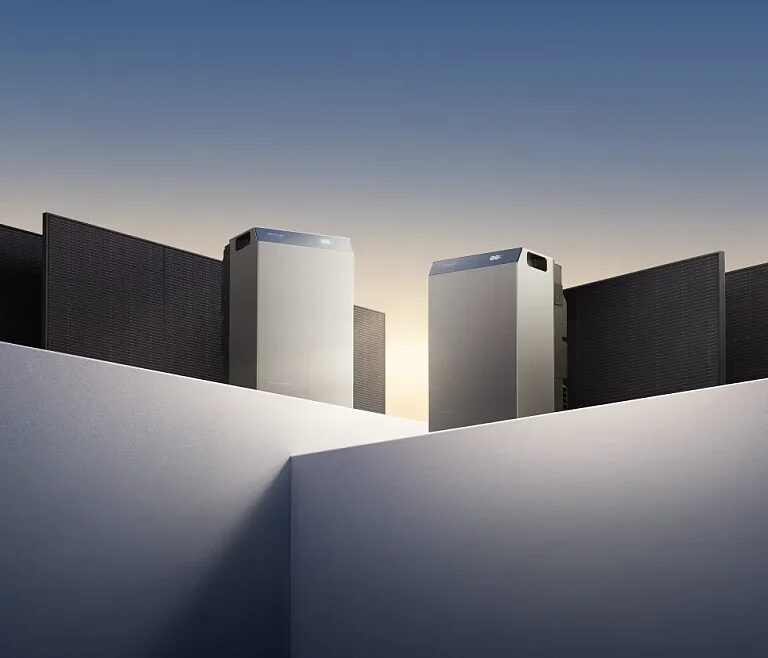 Two EcoFlow home battery storage units standing among solar panels in a stylised studio scene