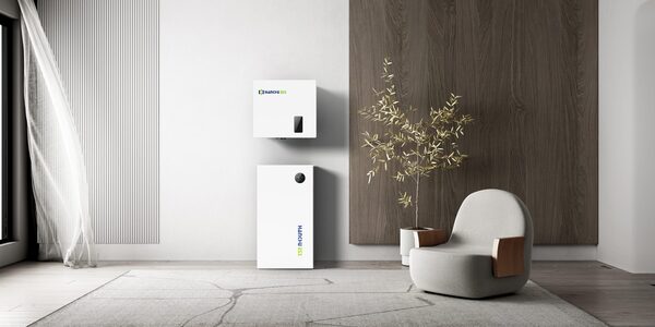 A Hanchu hybrid inverter and matching battery unit mounted on a wall in a styled modern interior