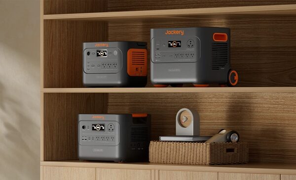 Three Jackery portable power stations displayed on wooden shelves in a home setting