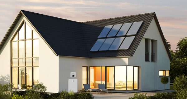 A modern house with rooftop solar panels and a Growatt battery storage unit mounted on the exterior wall