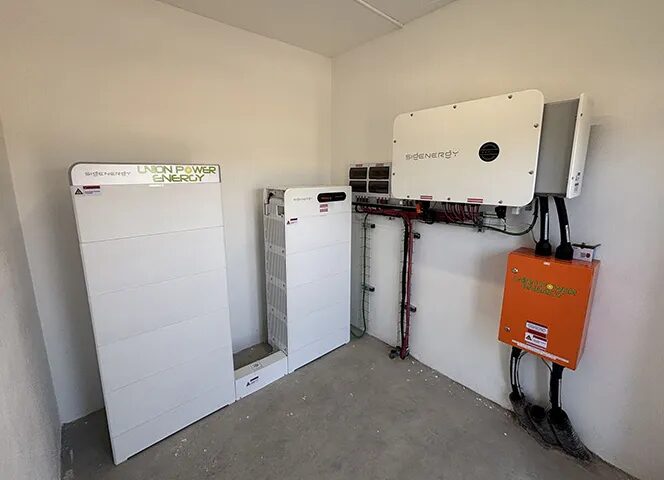 A Sigenergy home battery storage system with battery modules and an inverter installed in a garage or utility room