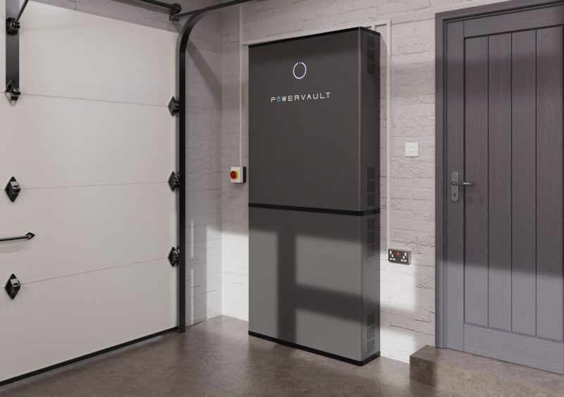 A Powervault home battery unit installed on the wall of a garage next to a grey door