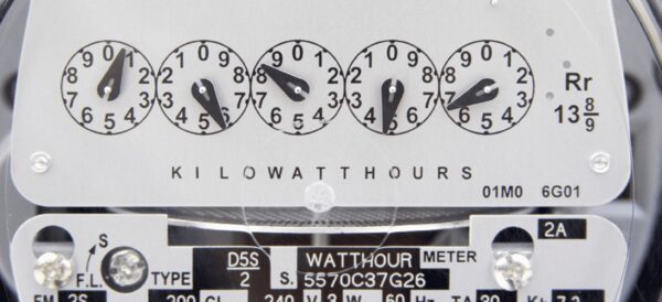 A close-up of a traditional dial electricity meter showing kilowatt-hour dials