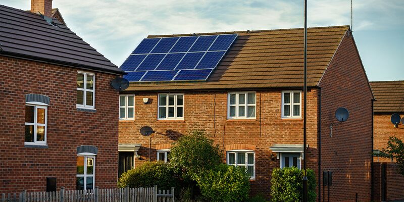 A brick UK semi-detached house with rooftop solar panels