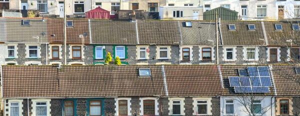 Rows of Welsh terraced houses with tiled roofs, one roof fitted with solar panels