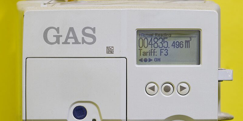 A close-up of a white digital domestic gas meter with a display showing a metric reading in cubic metres