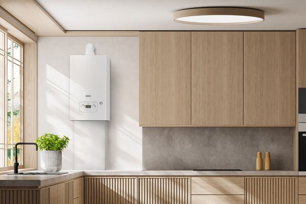 A white Baxi wall-mounted combi boiler installed in a modern light-wood kitchen