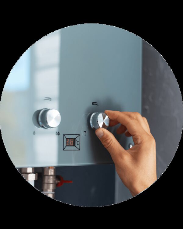 A hand turning the control dial on a wall-mounted combi boiler with a digital temperature display