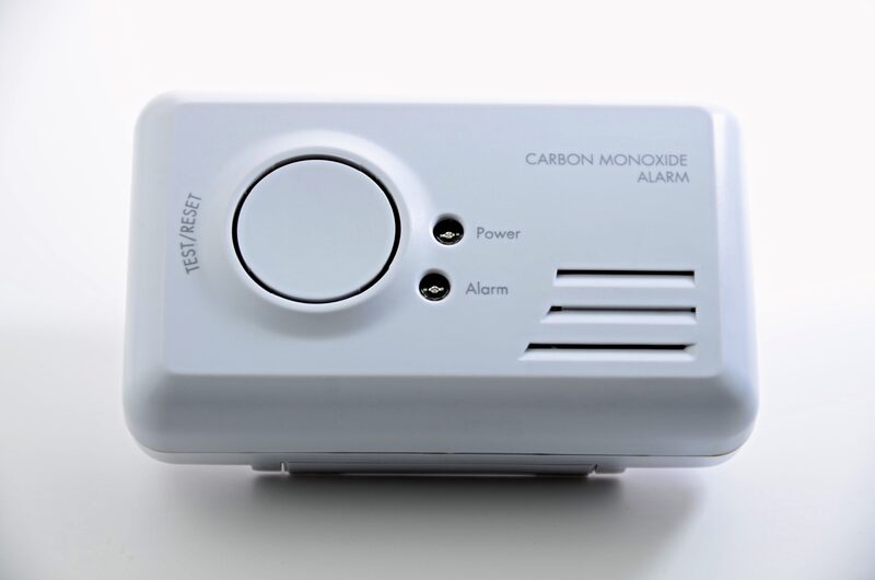 A white carbon monoxide alarm with test/reset button and power and alarm indicator lights