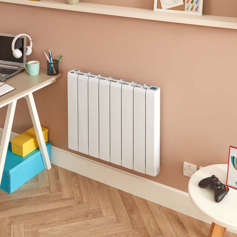 A white wall-mounted electric panel radiator installed on a pink wall in a home office