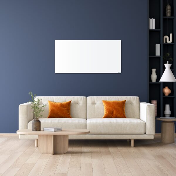 A white Herschel infrared heating panel mounted on a dark blue wall above a cream sofa in a living room