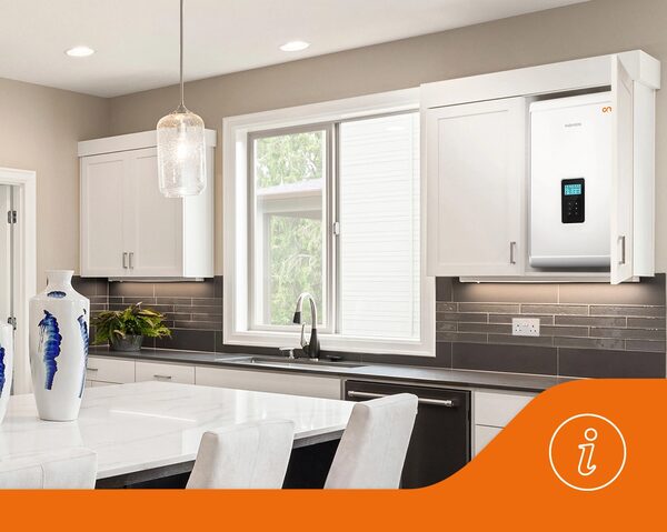 A Navien wall-mounted boiler installed inside a kitchen cupboard in a modern white kitchen