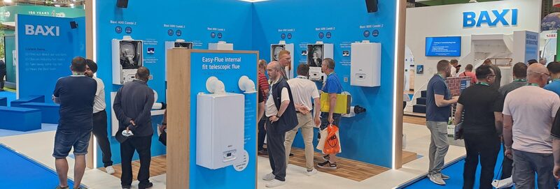 Baxi exhibition stand at a trade show displaying wall-mounted boilers and flue products with visitors browsing