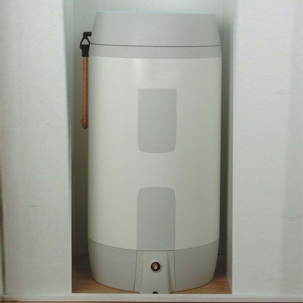 A white electric water heater cylinder installed in an airing cupboard with a copper pipe visible beside it