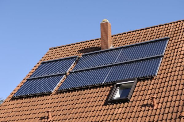 Evacuated-tube solar water heating collector panels installed on a tiled house roof