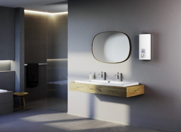A Stiebel Eltron DHE instantaneous water heater mounted on a bathroom wall above a washbasin