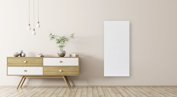 A white Sundirect Hybrid750-Pro infrared heater panel mounted on a beige wall above a wooden sideboard in a styled room