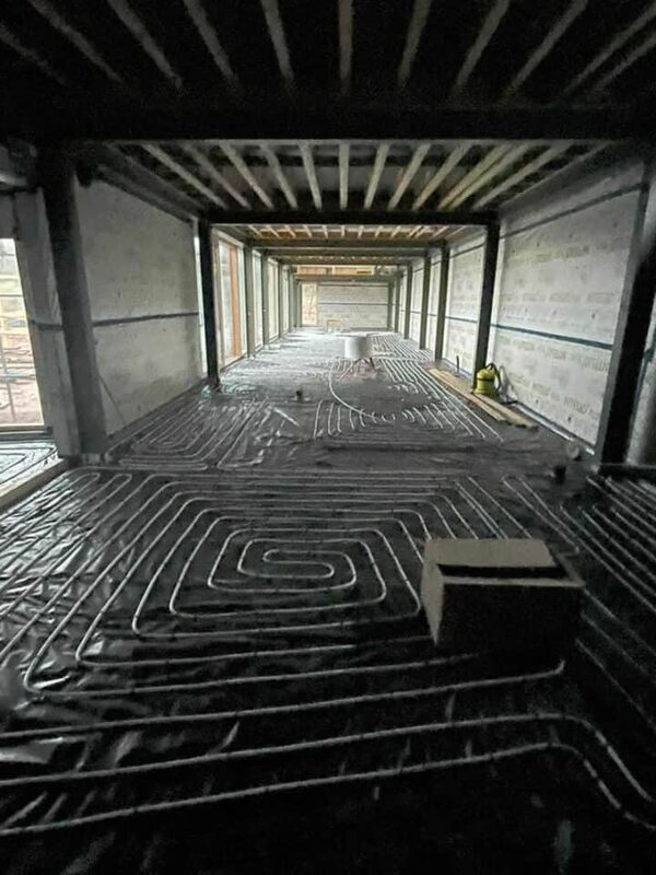 Underfloor heating pipes laid out across the floor of a building under construction