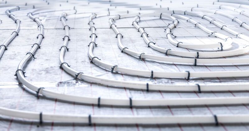 Underfloor heating pipes laid in loops and clipped to insulation on a floor before screeding