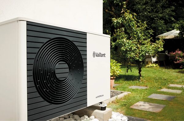 A Vaillant aroTHERM plus air source heat pump unit installed outside a house in a garden