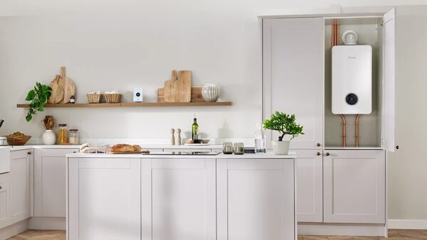 A white Worcester Bosch combi boiler installed in a cupboard in a pale grey kitchen