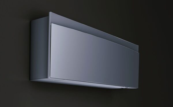 A sleek grey wall-mounted split air conditioning indoor unit against a dark wall