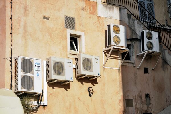 Several air conditioning condenser units mounted on the exterior wall of a building