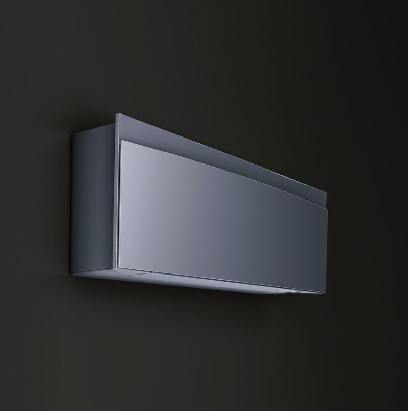 A sleek silver wall-mounted air conditioning indoor unit on a dark wall