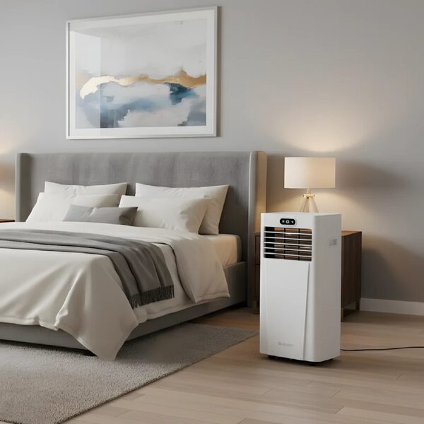 A white Meaco portable air conditioner standing on the floor of a grey and white bedroom beside a bedside table