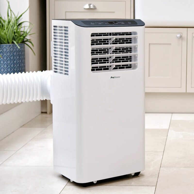 A white Pro Breeze portable air conditioner with an exhaust hose standing on a tiled kitchen floor