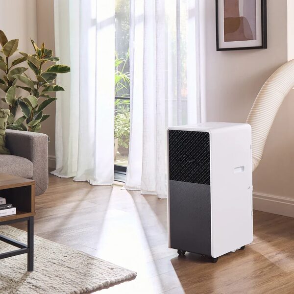 A white portable air conditioner with an exhaust hose installed in a bright living room