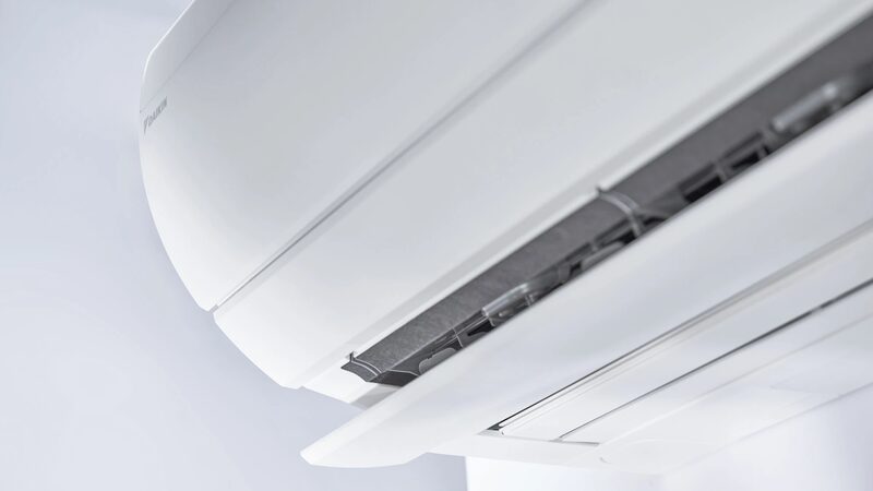Close-up of a white Daikin wall-mounted air conditioning indoor unit with the front panel open showing the filter