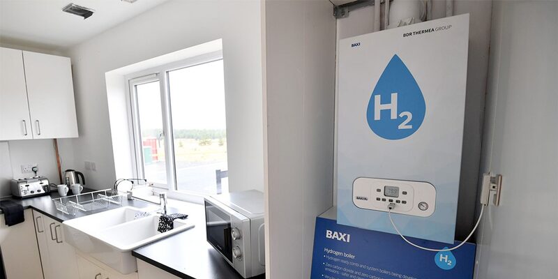 A Baxi hydrogen boiler with an H2 droplet logo mounted on a wall in a white kitchen