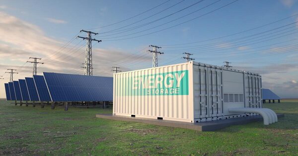 A containerised battery energy storage unit labelled 'Energy Storage' beside rows of solar panels and electricity pylons in a field