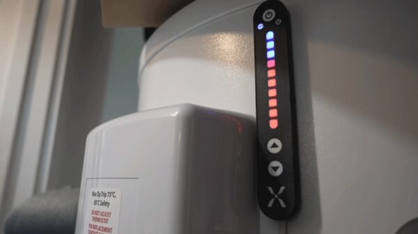 A Mixergy smart hot water cylinder with its vertical LED gauge showing charge level, installed indoors