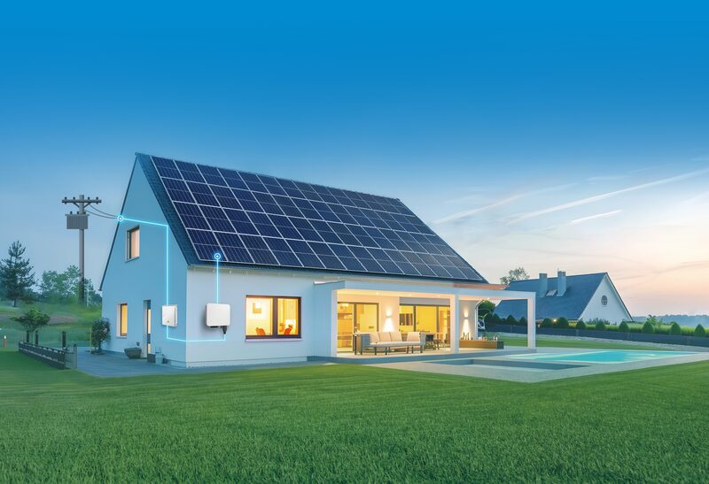 A modern house with rooftop solar panels, a wall-mounted battery/inverter unit and glowing connection lines illustrating a home energy system