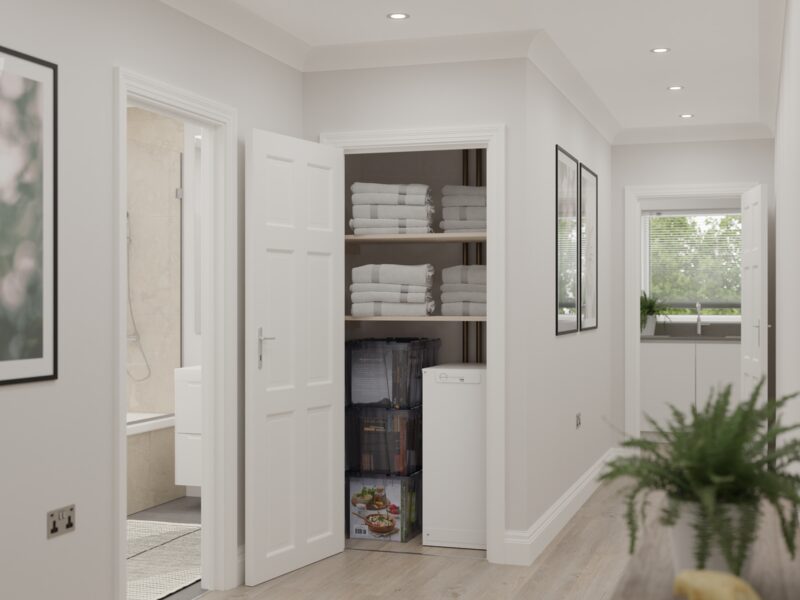 A white Sunamp thermal battery water heater unit installed in a household airing cupboard with towels on shelves above