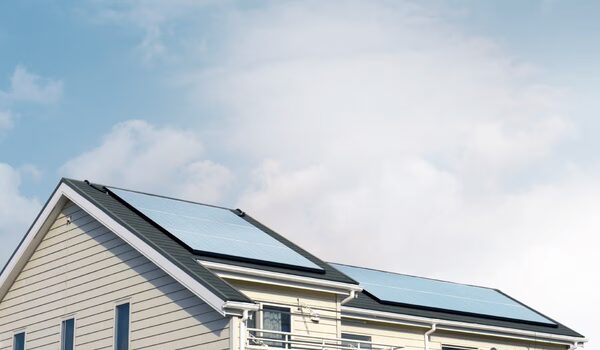 A house with solar panels installed on its roof against a cloudy sky