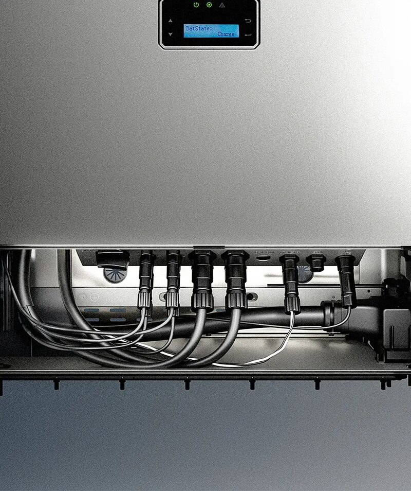 Close-up of the underside of a wall-mounted home battery unit showing its display and connected cables