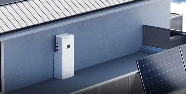 A LuxpowerTek wall-mounted home battery storage unit installed on an exterior house wall next to solar panels