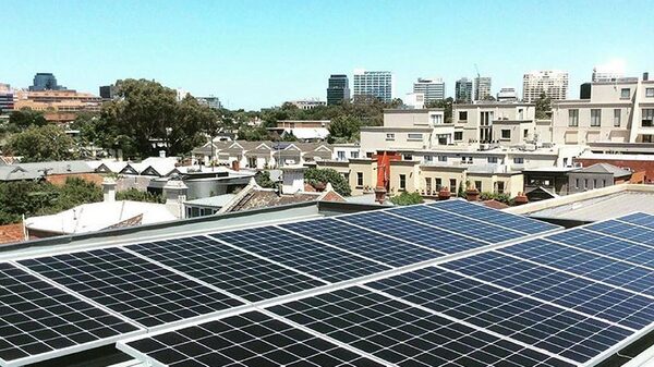Rooftop solar panels on a building overlooking a city skyline