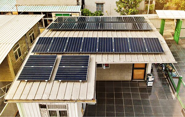 Solar panels installed on the corrugated metal roof of a house, seen from above