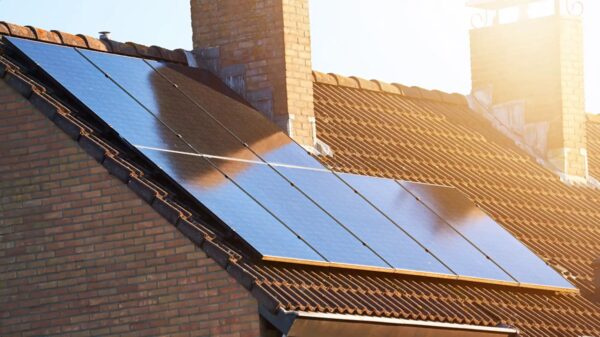 Solar panels installed on the tiled roof of a brick house in sunlight
