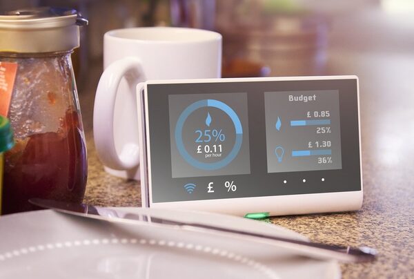A smart energy monitor on a kitchen worktop displaying real-time energy use and budget figures