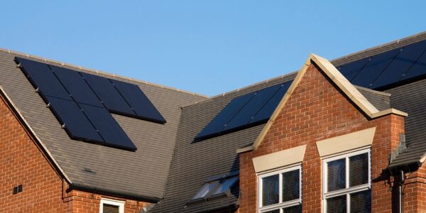 Solar panels fitted on the tiled roof of a modern brick-built UK house