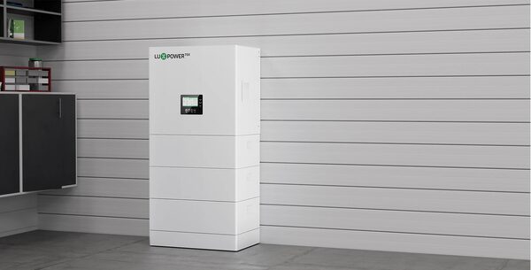A white LuxpowerTek stacked home battery storage unit standing against a grey panelled wall in a room