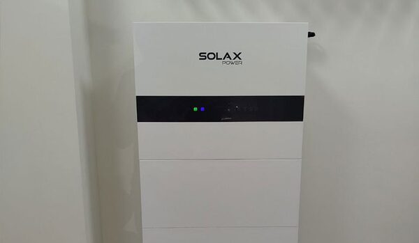 A white SolaX Power home battery storage unit mounted against a plain wall