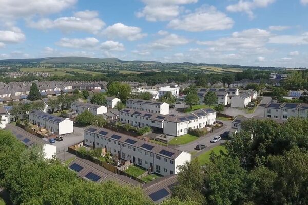 Aerial view of a housing estate with solar panels on many rooftops